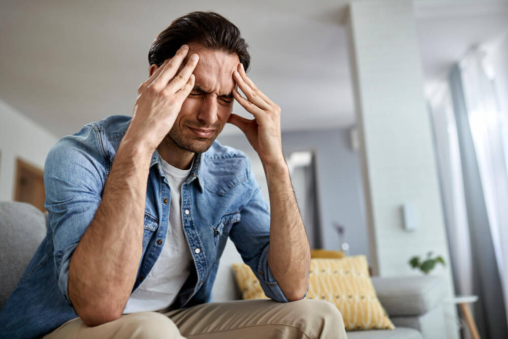 Man Sitting and Holding His Head