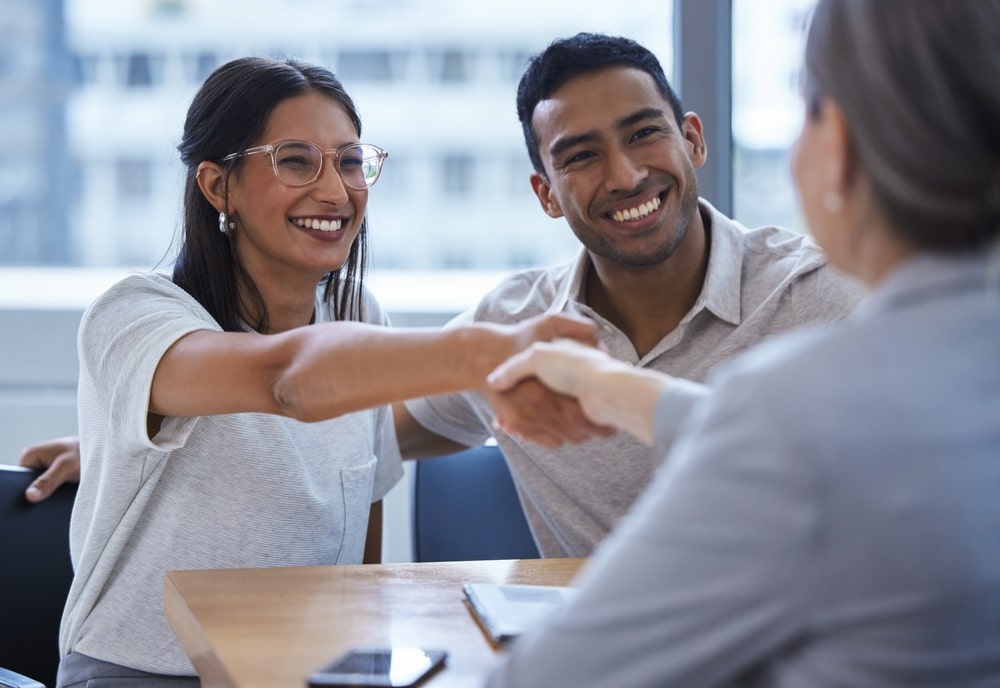 Smiling Clients Shaking Hands With Their Attorney